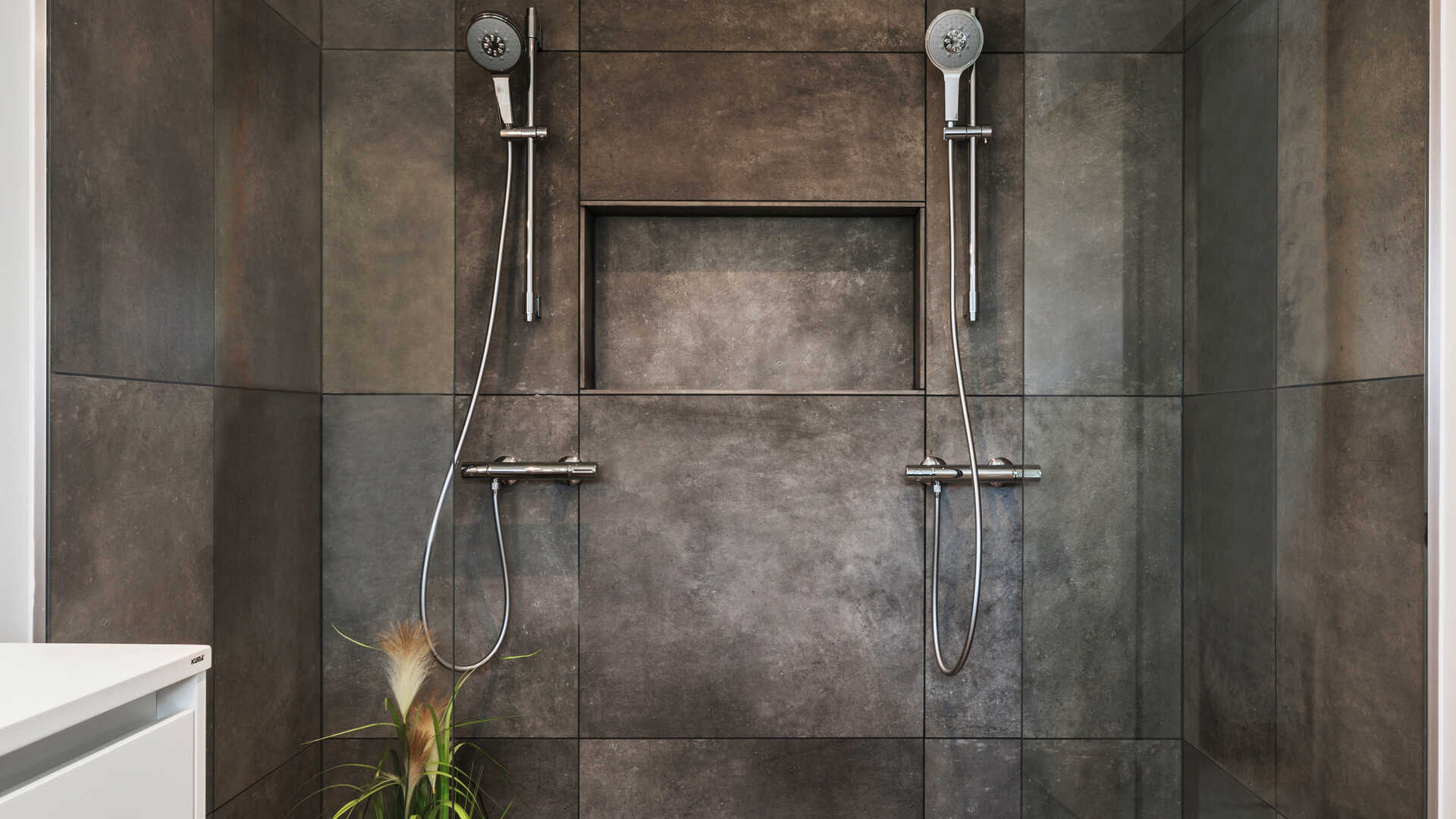 HusCompagniet tilbyder jer et næsten ubegrænset udvalg af klinker og fliser til bl.a badeværelserne. Her er valgt et dramatisk mørkt naturstens-look der gør hele badeværelset eksklusivt og smukt. 