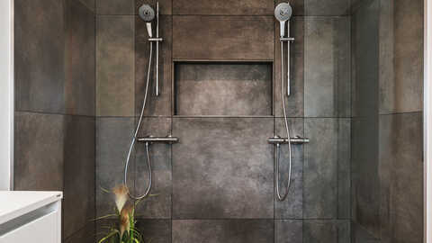 HusCompagniet tilbyder jer et næsten ubegrænset udvalg af klinker og fliser til bl.a badeværelserne. Her er valgt et dramatisk mørkt naturstens-look der gør hele badeværelset eksklusivt og smukt. 